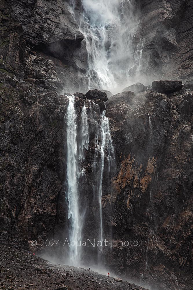 Face à la grandeur de la Cascade de Gavarnie, une roche sombre et une eau qui se vaporise au contact du soleil