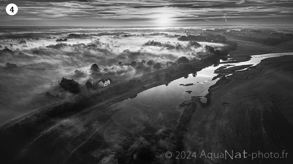 Vue aérienne des brumes rasantes dans la vallée de la Loire au lever du soleil en noir et blanc