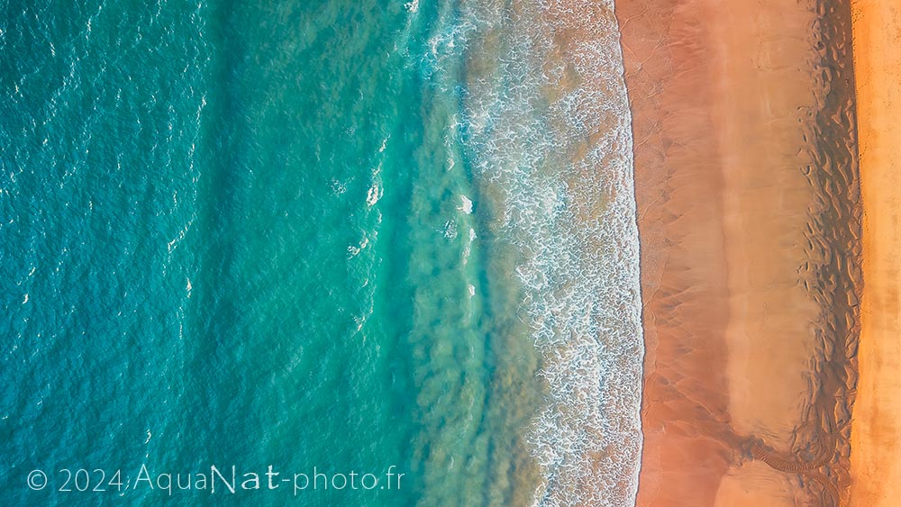 vue aérienne verticale mer turquoise et plage de sable fin